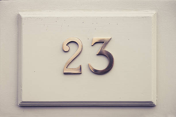 Twenty three (23) door number on white wood