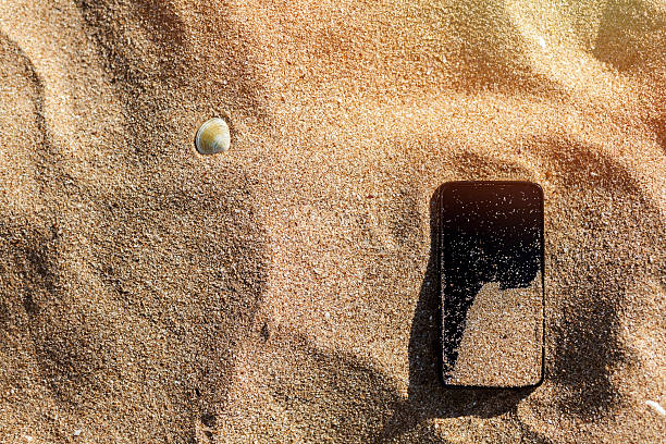 perdido teléfono en la arena de la playa - lost beach fotografías e imágenes de stock