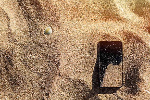 lost phone in the sand - lost phone stockfoto's en -beelden