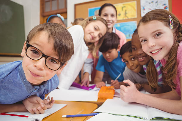 istock Teacher and pupils working at desk together 486172878