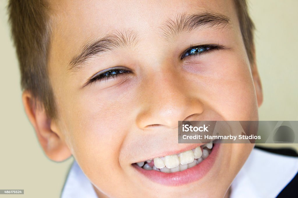 Close-up portrait of little boy with content smile Close-up portrait of little boy with content smile. High angle view of little boy laughing against colored background. Focus on boy. Horizontal composition. Image developed from Raw format. 2015 Stock Photo