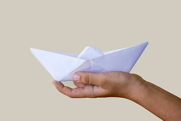 istock Human hand holding paper boat 486180946
