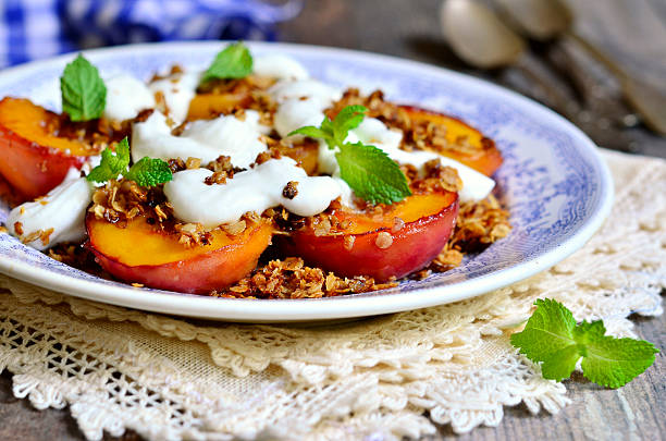 granola y peachs asado con crema batida. - dessert grilled peaches peach fotografías e imágenes de stock