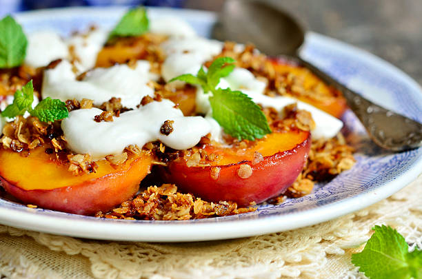 granola y peachs asado con crema batida. - dessert grilled peaches peach fotografías e imágenes de stock