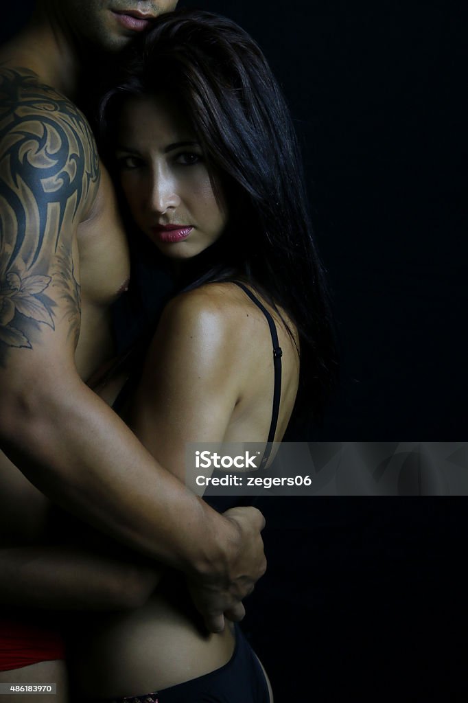 Young couple wearing underwear beautiful woman resting her head against a male torso Tattoo Stock Photo