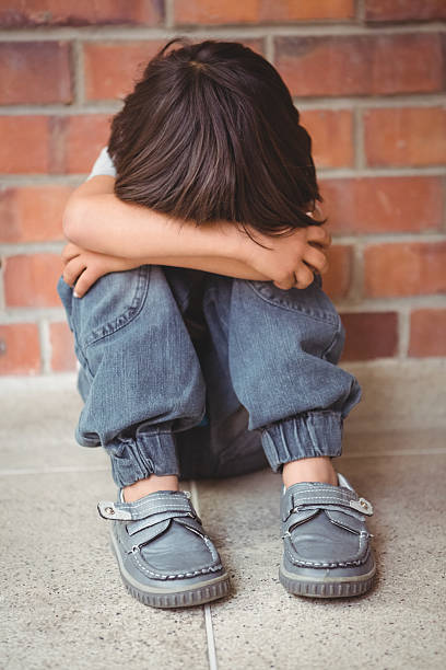 istock Upset lonely child sitting by himself 486184618