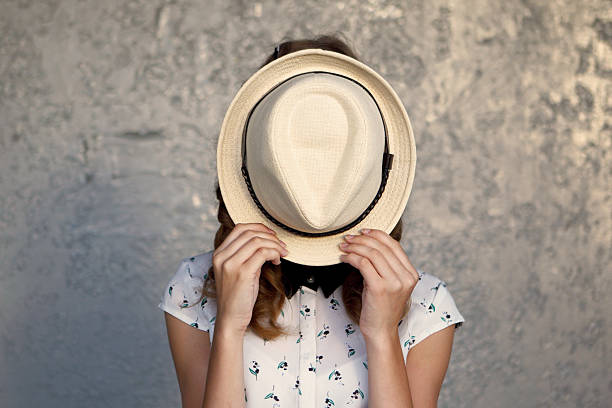 istock Young girl with hat. Hides her face.Depression. 486184768