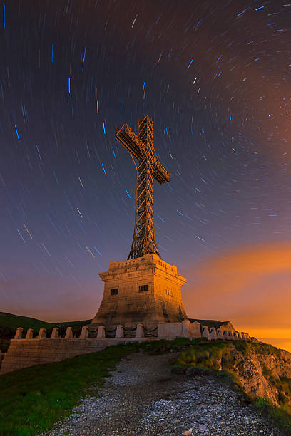 istock Star trails in the night sky above Cross Monument 486200339