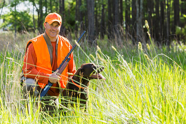 istock Man hunting with shotgun kneeling next to retriever 486202636