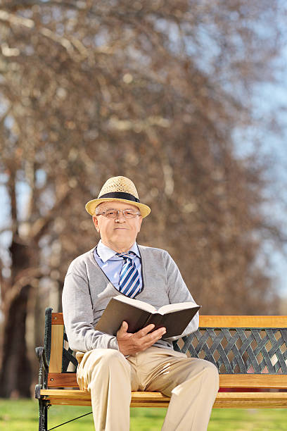 istock Senior reading a book in park on sunny day 486202785