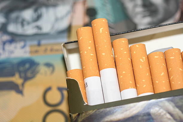 Packet of open cigarettes and Australian notes. stock photo
