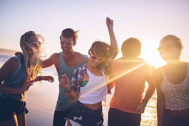 istock Friends dancing on beach in sunset 486203651
