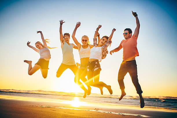 istock Friends jumping on beach in sunset 486204197