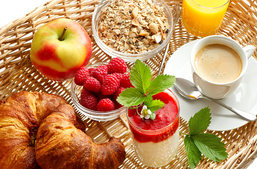 Breakfast with coffee, croissants, orange juice and fresh strawberry yogurt