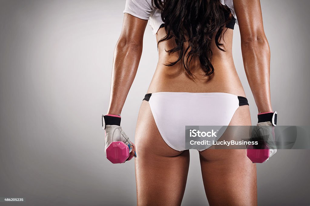 sexy ass of sportswoman sexy ass of sportswoman with dumbbells, back view Sensuality Stock Photo