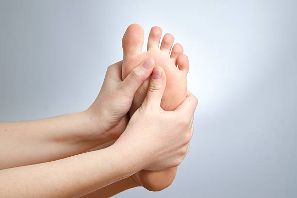 dolore nel piede - podiatrist chiropractor massaging human foot foto e immagini stock