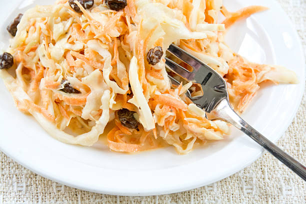 Coleslaw with raisins and fork stock photo