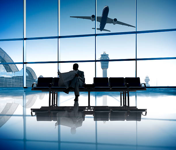 istock Businessman Reading the Newspaper While Waiting for His Flight 486207401