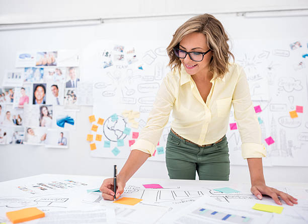 Woman drawing a business plan Woman in her 20s drawing a creative business plan at the office market research photos stock pictures, royalty-free photos & images