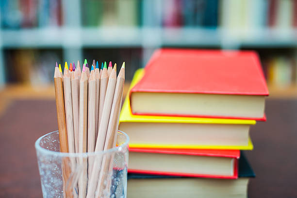 istock Colored pencils with pile of books in background 486227994