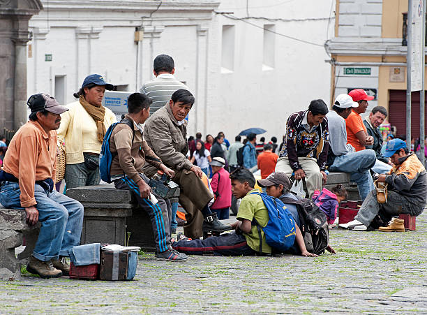 Gathering for help, Quito, Ecuador Quito, Ecuador - November 15, 2014: Poor locals chatter whilst they gather on stone benches in the Plaza de San Francisco, whilst waiting for state and charitable handouts in the early morning in old Quito, Ecuador beg alms stock pictures, royalty-free photos & images