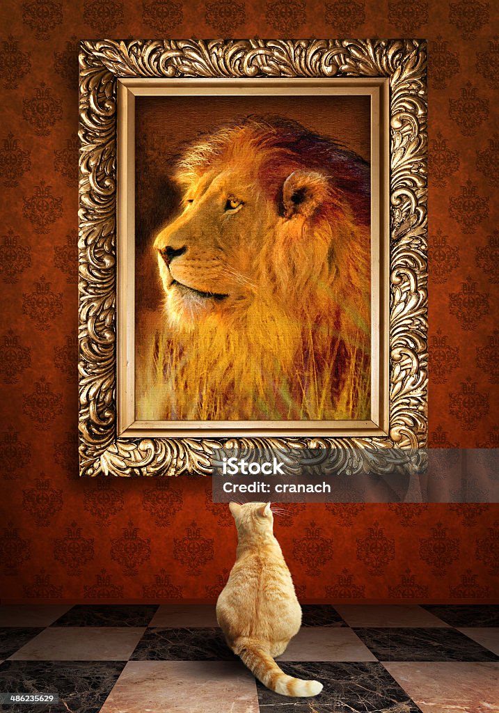 Cat looking at a portrait of lion in golden frame. Lion - Feline Stock Photo