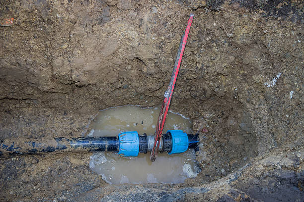 istock broken pvc pipe in trench with wrench leaks water 486236009