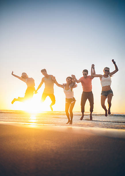 istock Friends jumping on beach in sunset 486241549
