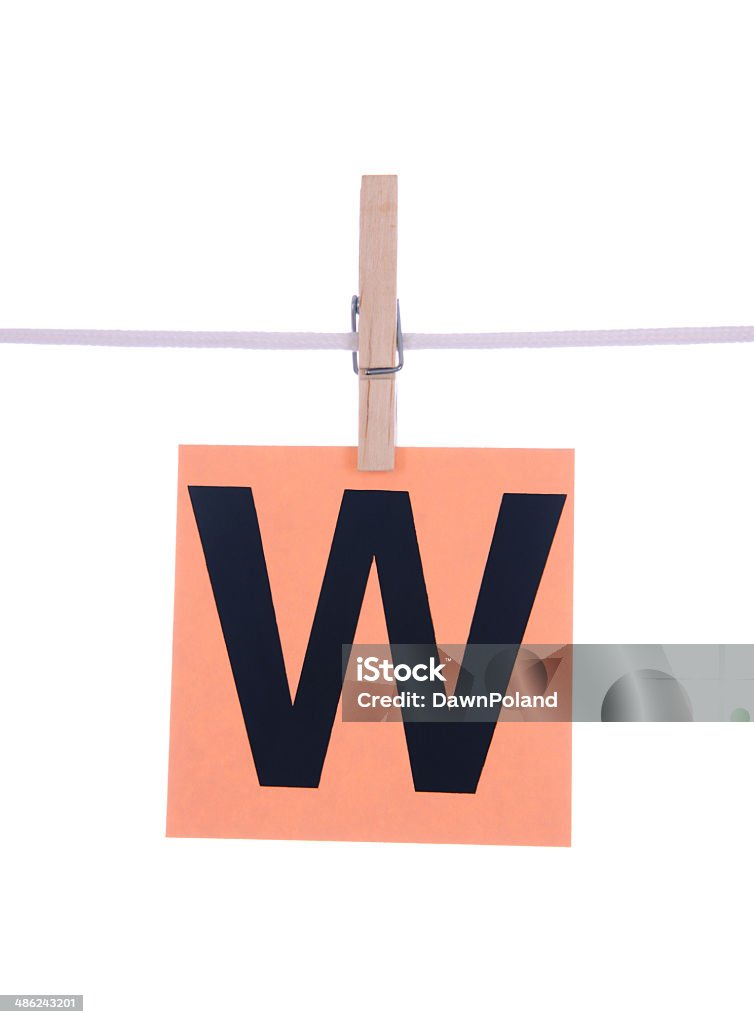 Letter W Letter W on peach paper hanging on a clothesline on a white background. Adhesive Note Stock Photo