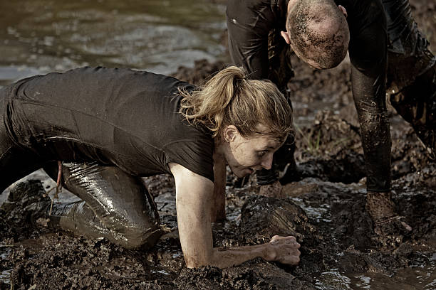 istock couple getting out of the canal during mud run 486249346