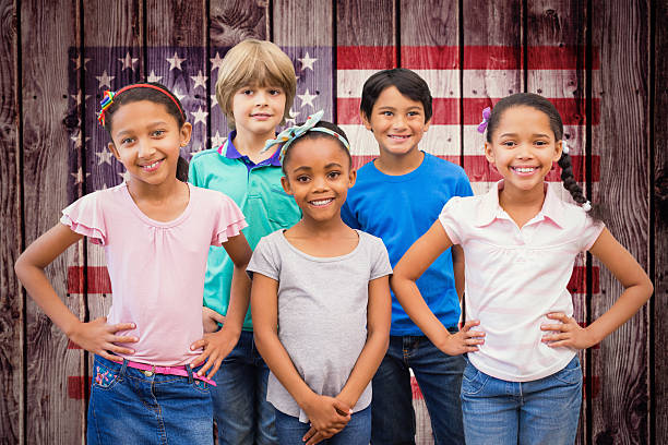 istock Composite image of cute pupils smiling at camera in classroom 486249726