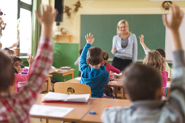 istock Rear view of elementary school children answering the question. 486255462