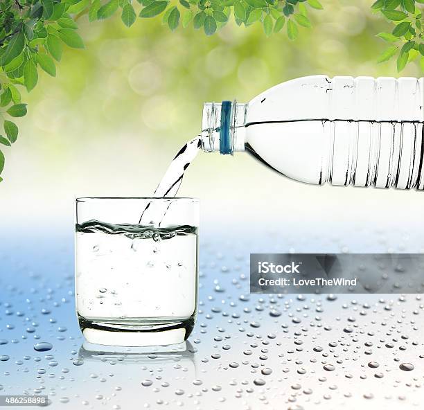 Drinking Water Is Poured From A Bottle Into A Glass Stock Photo - Download Image Now