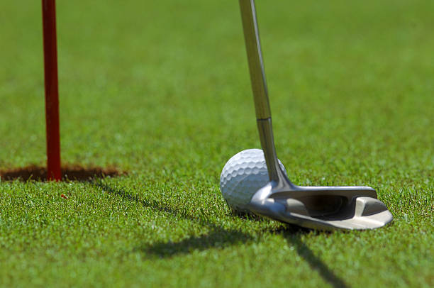 istock Golf player at the putting green hitting ball 486263482