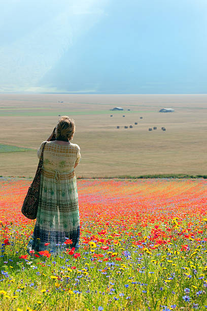 photographe en robe longue bleu-vert près de castelluccio, italie - natural landmark outdoors vertical saturated color photos et images de collection