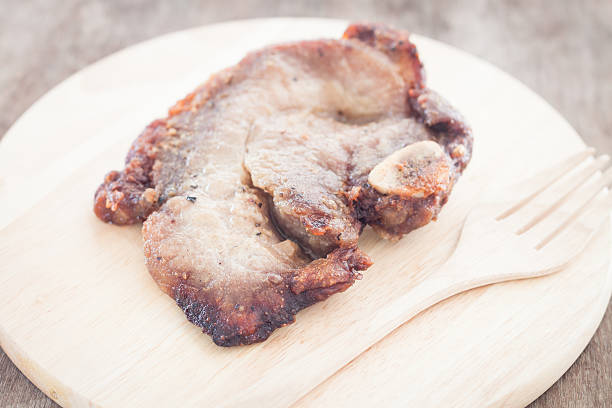 Pork steak on wooden plate, stock photo