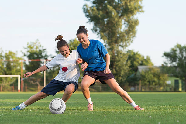 ladies soccer two female soccer players on the field soccer soccer ball kicking adult stock pictures, royalty-free photos & images