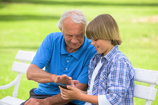 istock Grandfather and grandson using mobile phone 486267402
