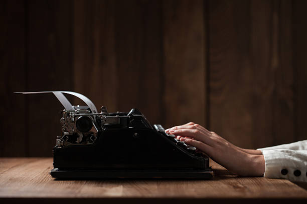 istock Hands writing on old typewriter over wooden table background 486273838