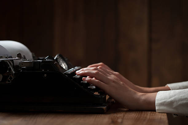 istock Hands writing on old typewriter over wooden table background 486273888