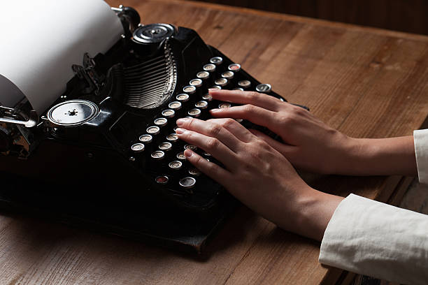 istock Hands writing on old typewriter over wooden table background 486273918