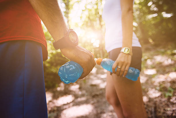 Two people pose on a trail with sport drink stock photo
