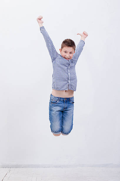 istock happy young boy jumping  on white background 486278120