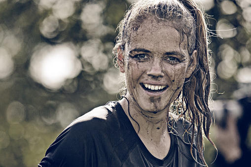 close up of happy woman covered by mud