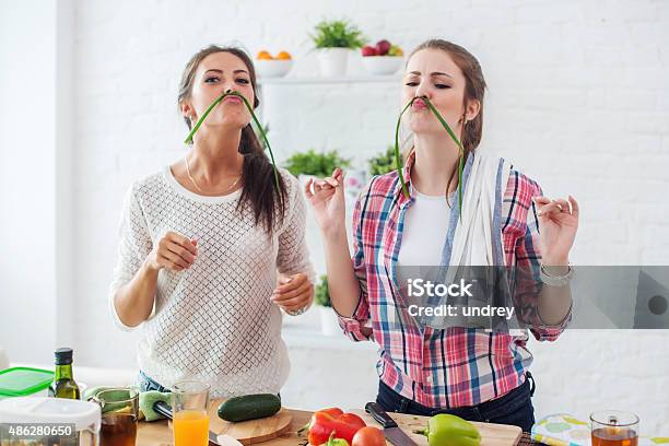 Women Preparing Healthy Food Playing With Vegetables In Kitchen Having Stock Photo - Download Image Now