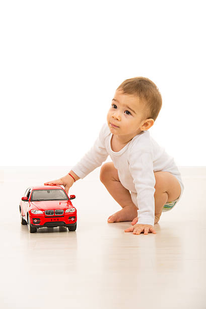 istock Toddler boy playing with red car 486287539