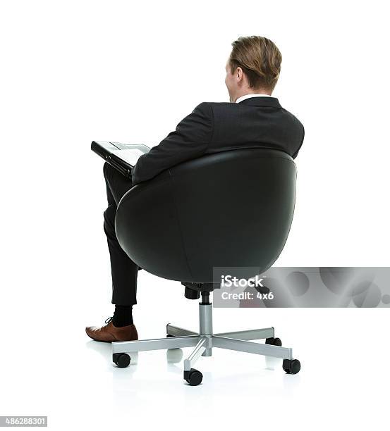 Rear View Of Businessman Sitting On Chair Stock Photo - Download Image Now - Males, Office Chair, Rear View