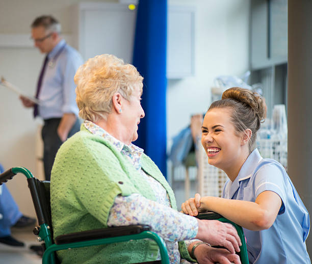 senior female patient in hospital senior woman laughing with nurse on the ward or nursing home happiness four people cheerful senior adult stock pictures, royalty-free photos & images
