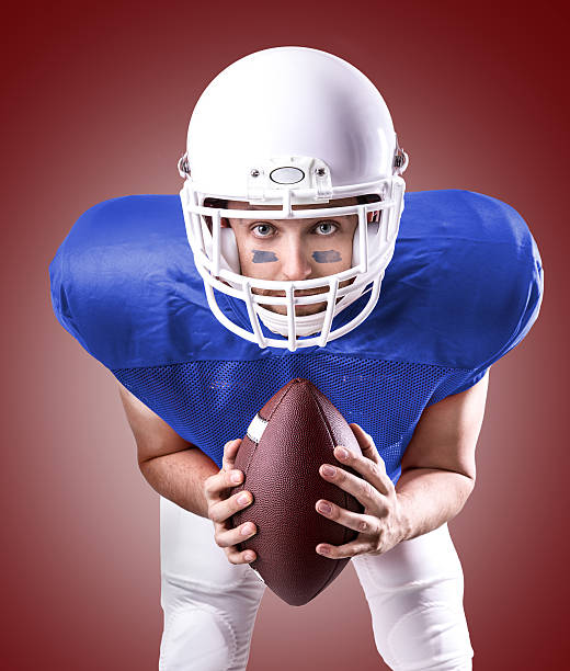 istock Football Player on blue uniform isolated on red background 486290334