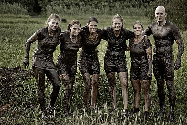 istock group of friends posing together after mud obstacle 486294230